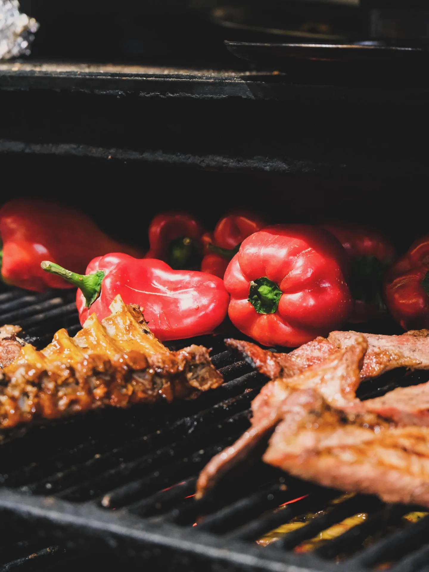 Red peppers, ribs and chicken over the charcoal grill at Tierra de Fuegos